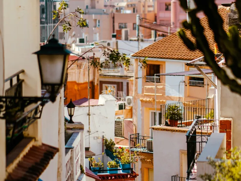 Vista de una calle del centro de Alicante con balcones y farolas tradicionales