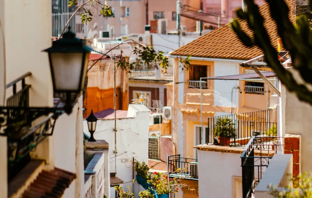 Vista de una calle del centro de Alicante con balcones y farolas tradicionales