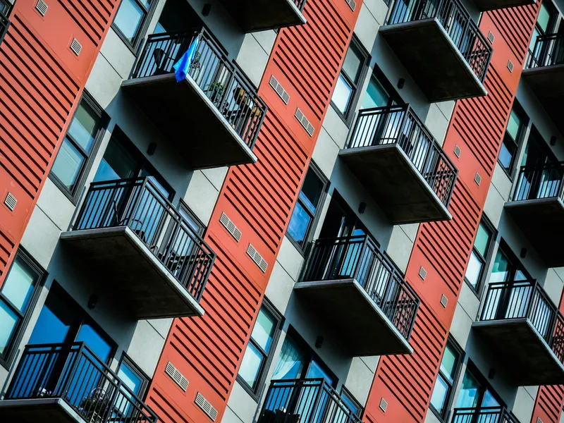 Tall red apartment building with balconies