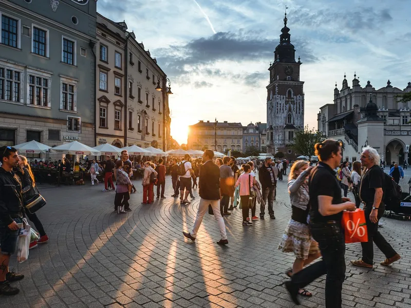 People walking down a street next to concrete buildings